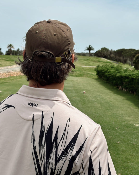Back of a golfer wearing a Volpe polo with focus on the logo on back nape