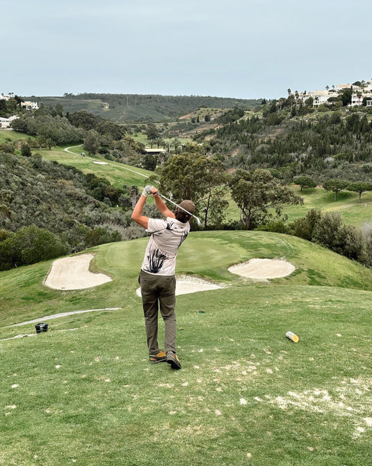 Golfer in Volpe polo mid swing on a par three in Portugal