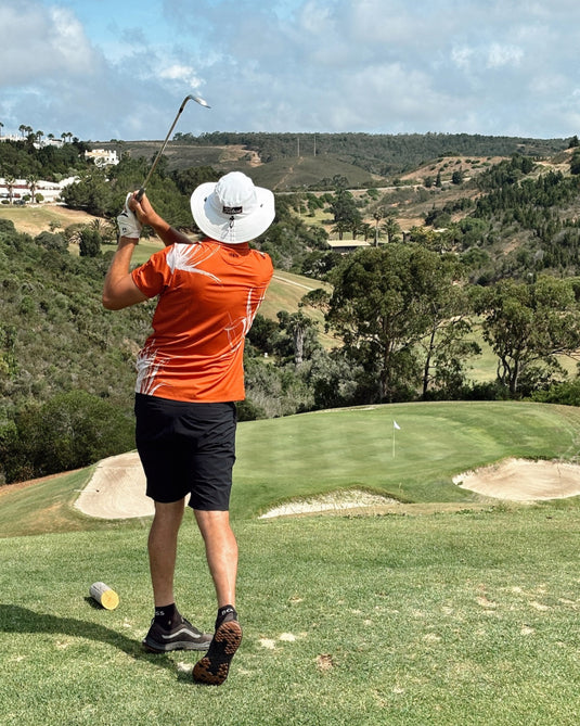 Golfer in Volpe polo mid swing on a par three somewhere in Portugal