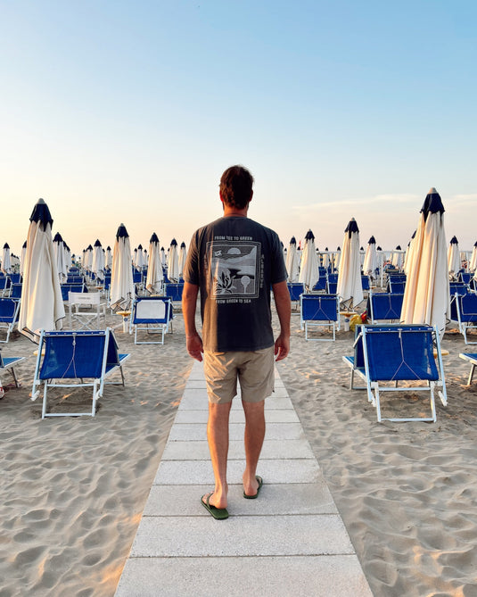 Person on a beach in italy wearing a Volpe graphic t-shirt