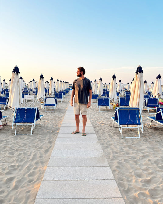 Person on a beach in Italy wearing a Volpe graphic t-shirt